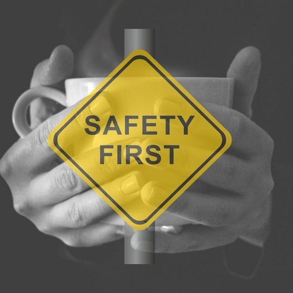 A sign board of safety first with a background of a warm cup